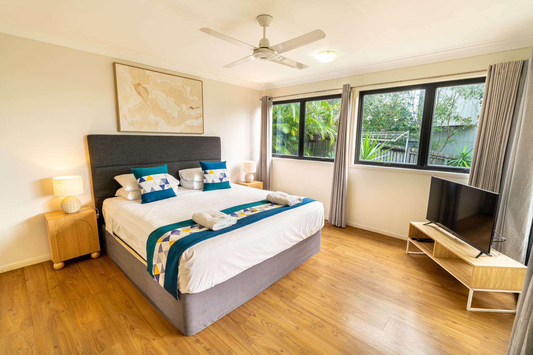 A bedroom at 8th on Roseby with a king bed, ceiling fan and television