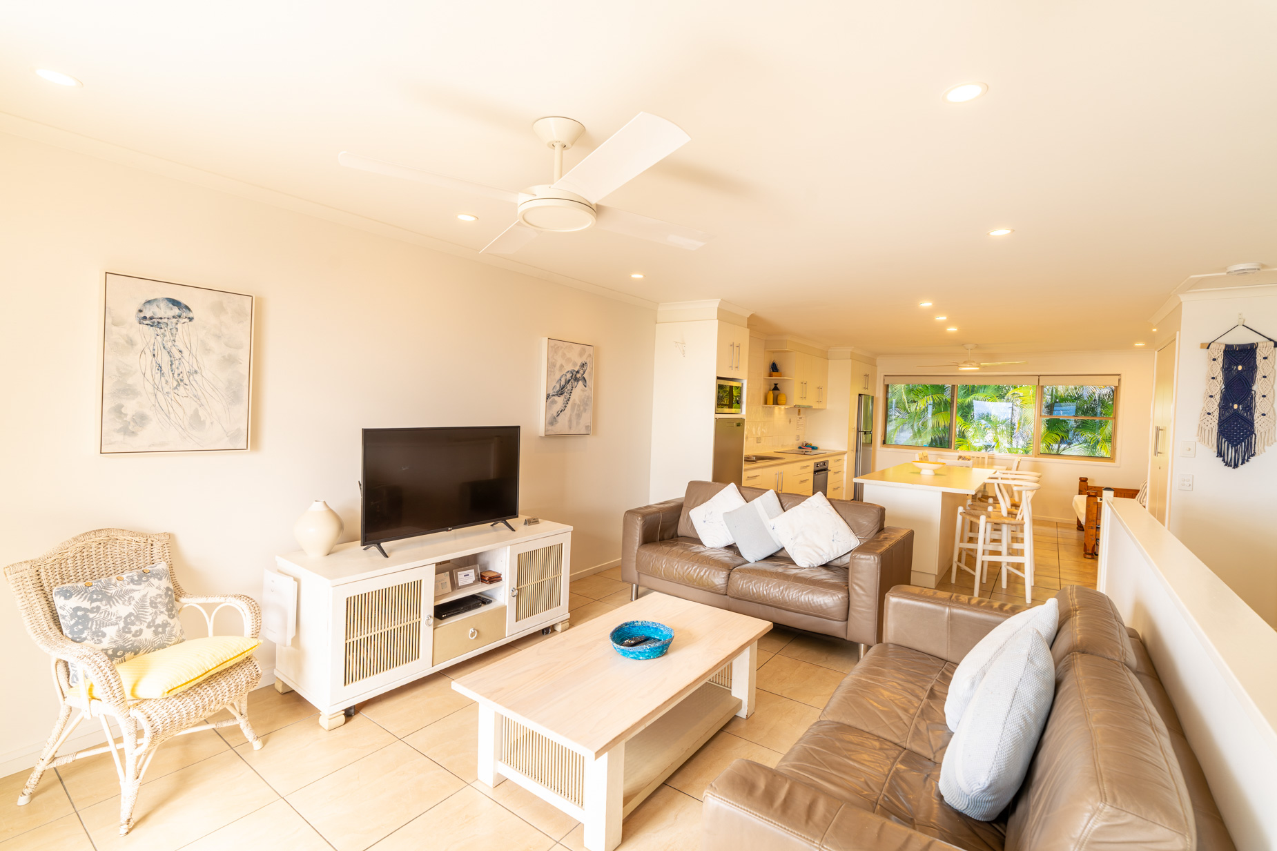 Open plan living room and kitchen inside a Deluxe Ocean villa at Pandanus Palms Resort
