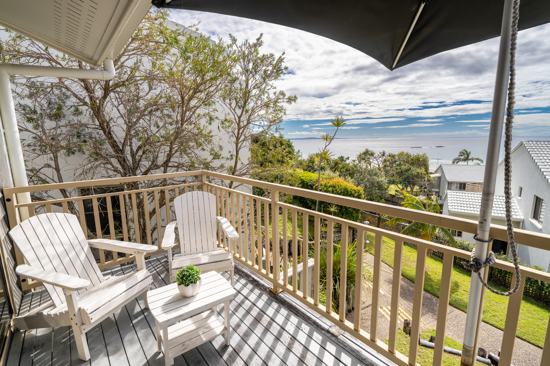 The private balcony of a Standard Ocean villa, with outdoor table and chairs among the palms