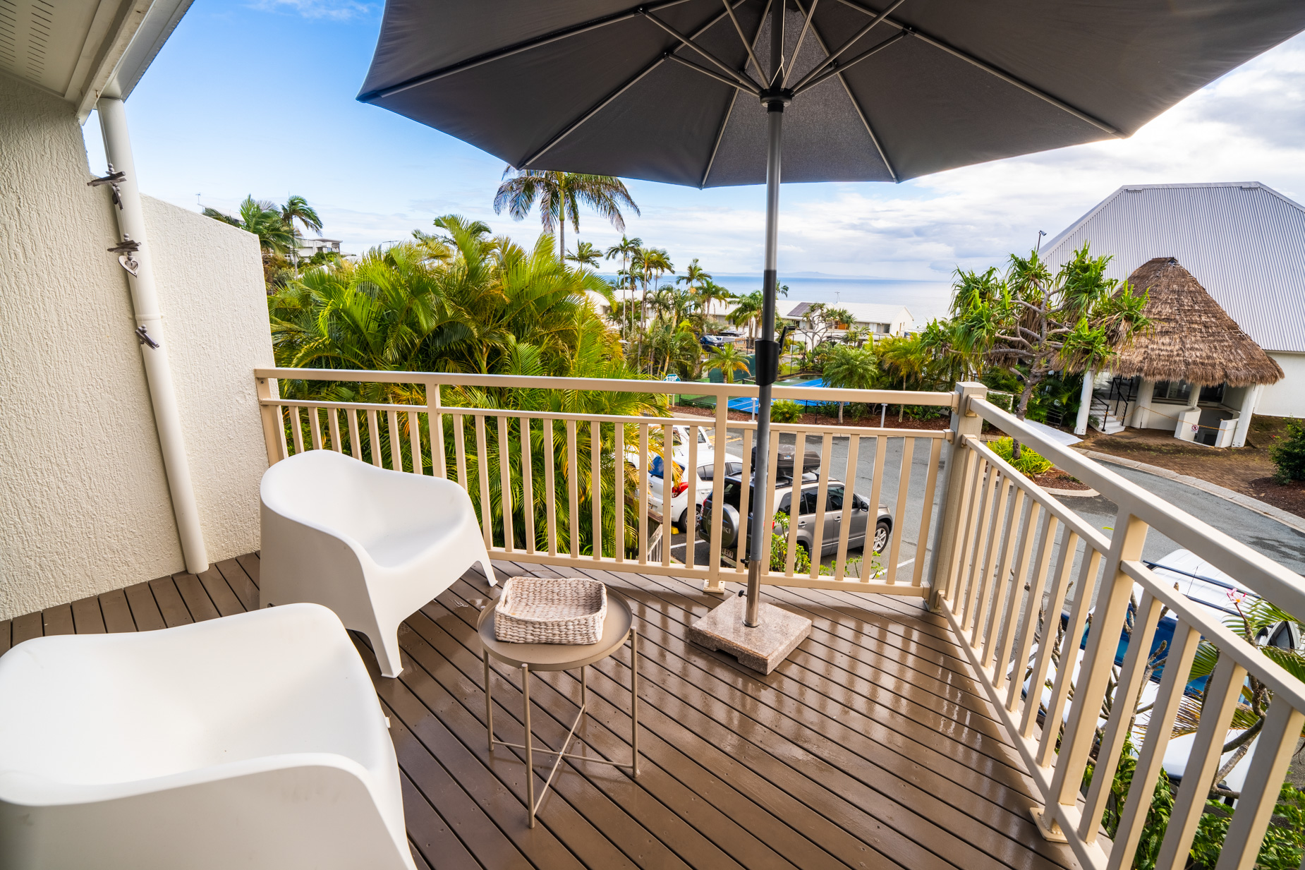 The private balcony of a Standard Ocean villa, with outdoor table and chairs among the palms