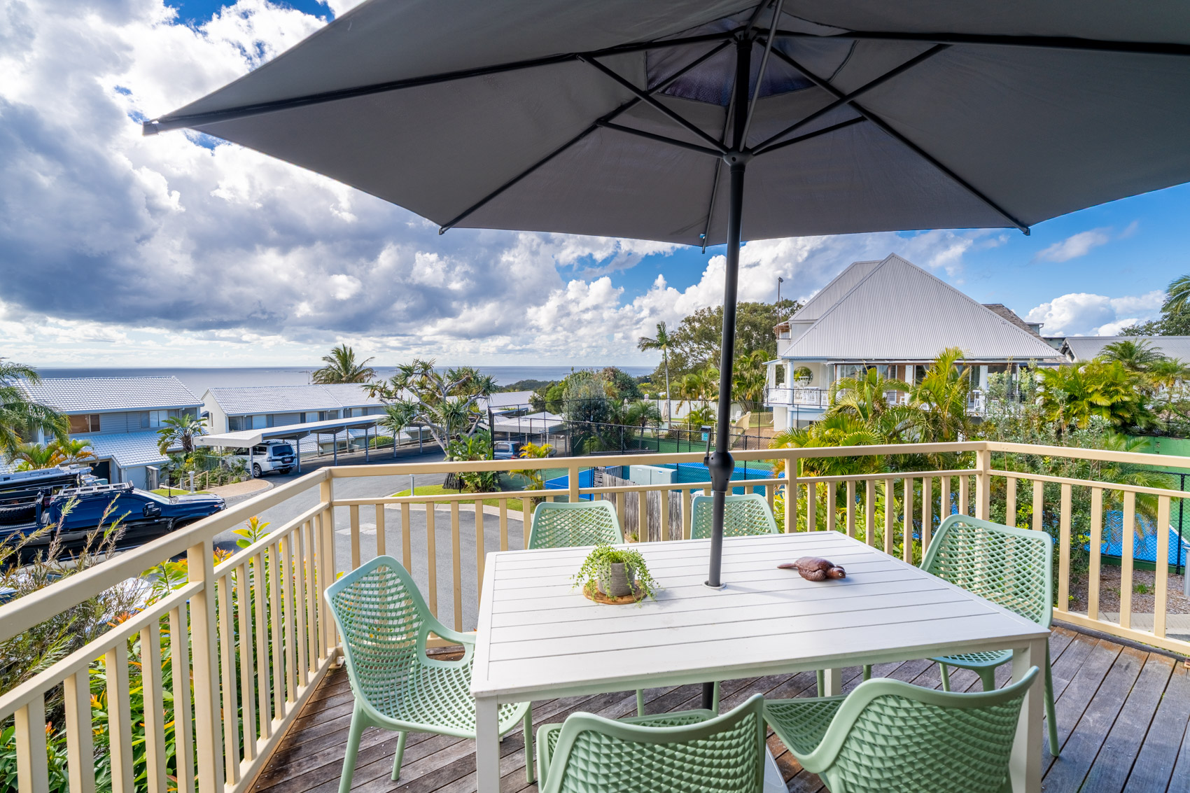 The private balcony of a Standard Ocean 3 bedroom villa, with outdoor table and chairs among the palms