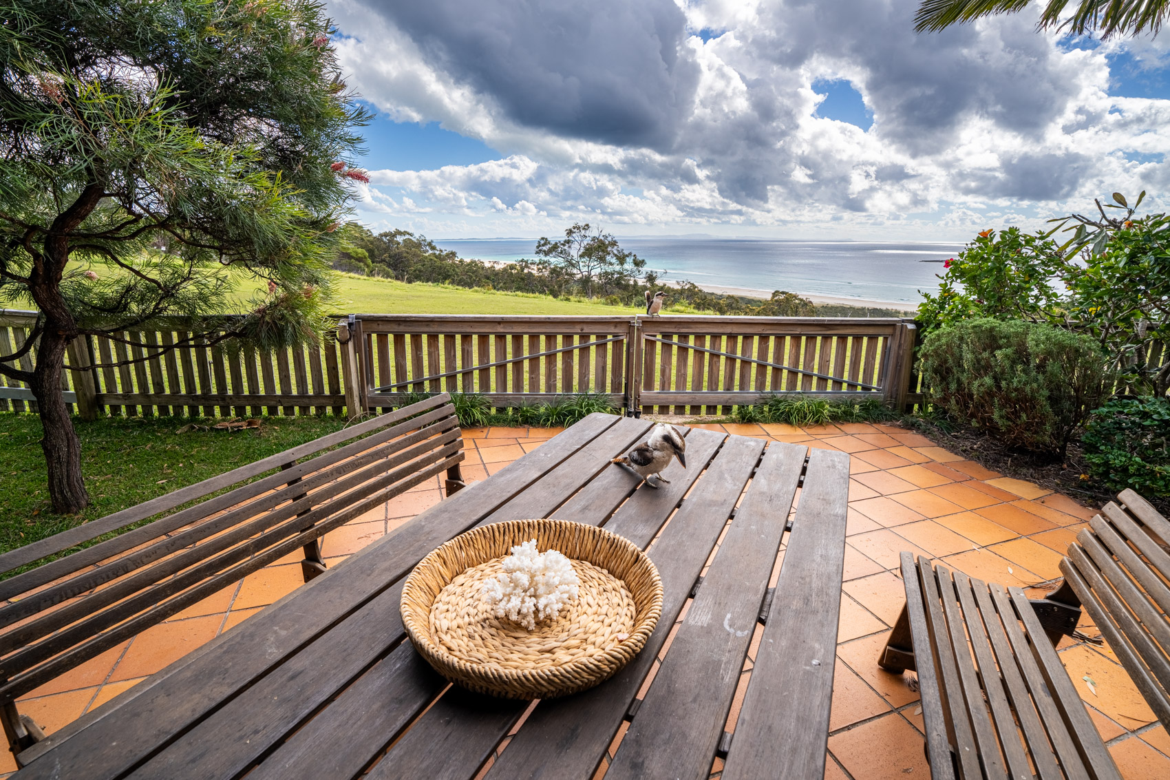 The private deck of a Prestige Headland Ocean 3 bedroom villa, with outdoor dining looking over the headland to the sea