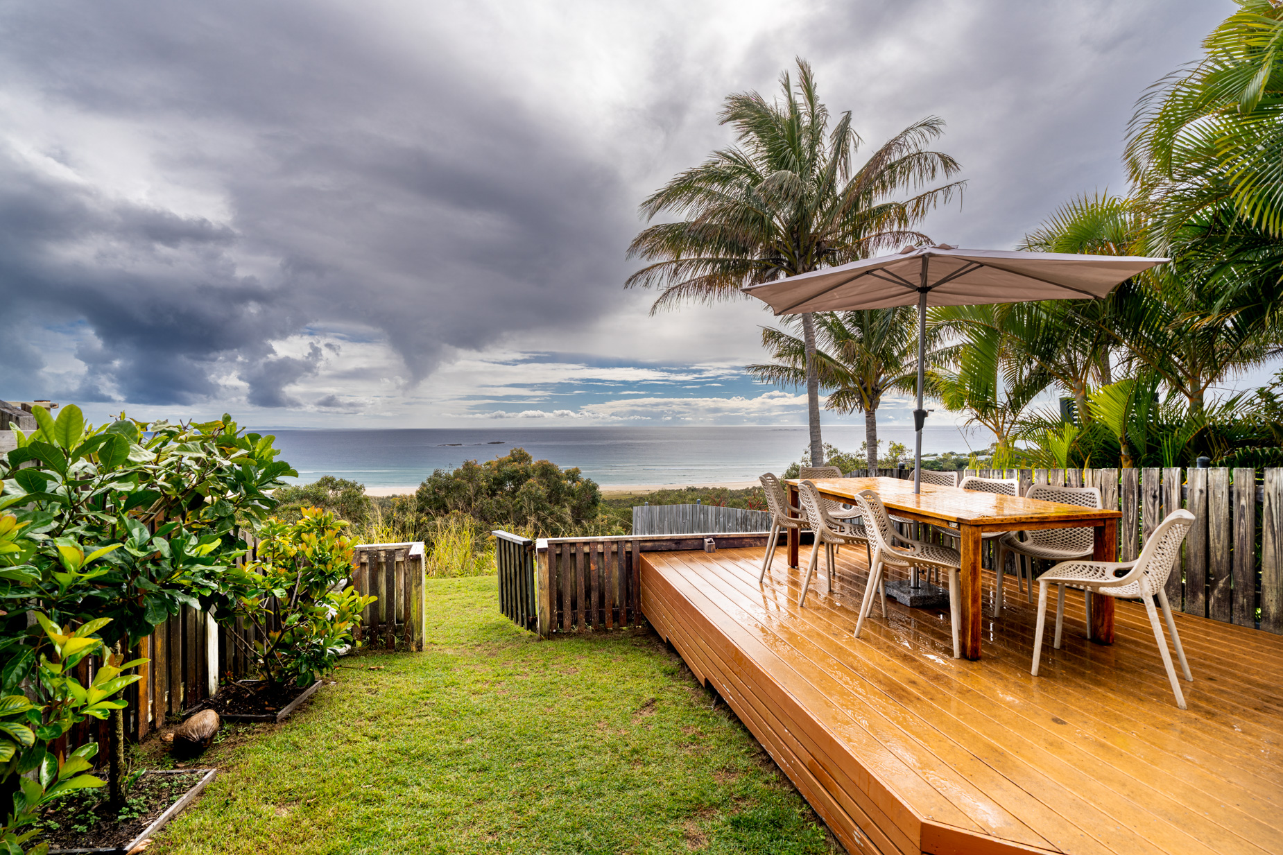 The private deck of a Prestige Headland Ocean 3 bedroom villa, with outdoor dining looking over the headland to the sea