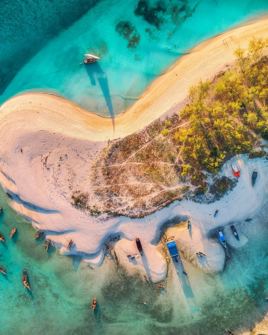 Clear shallow water running along a sandspit seen from above