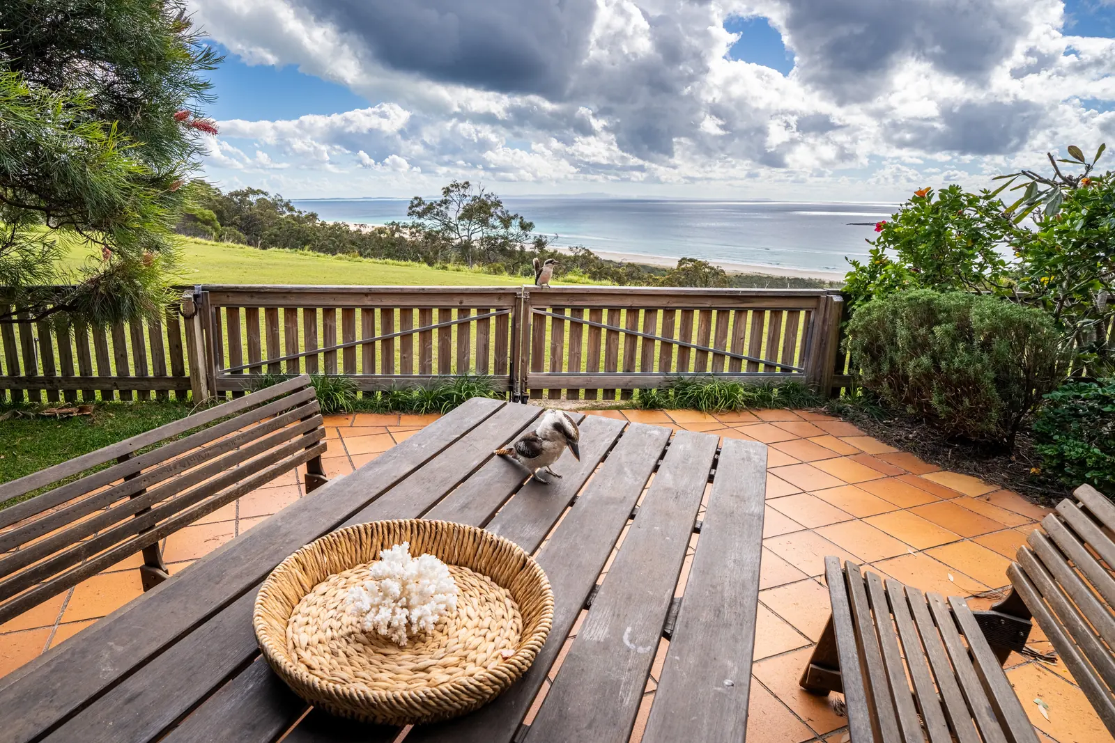The private deck of a Prestige Headland Ocean 3 bedroom villa, with outdoor dining looking over the headland to the ocean