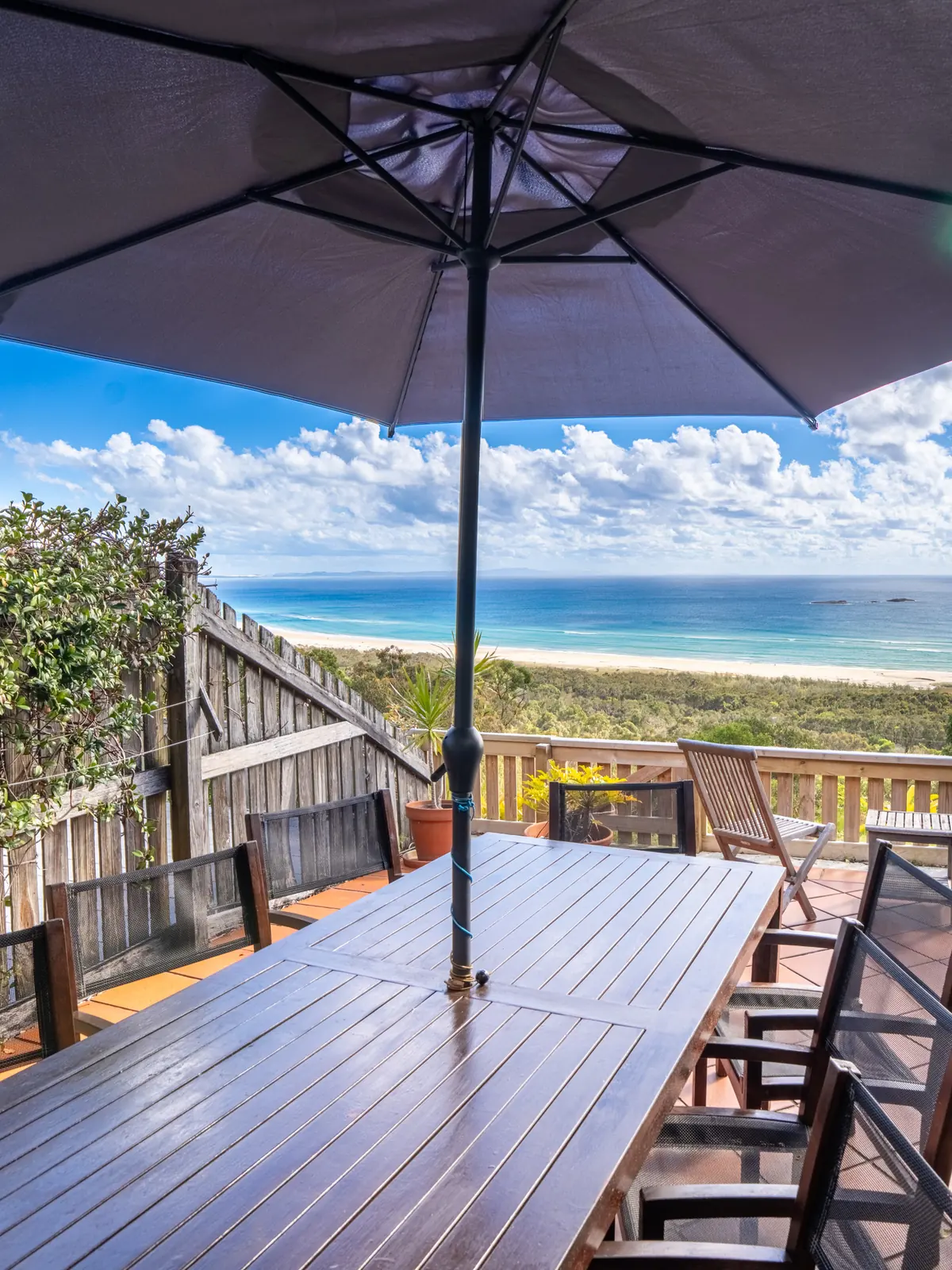 The private deck of a Premium Headland Ocean villa, with outdoor dining looking over the headland to the ocean