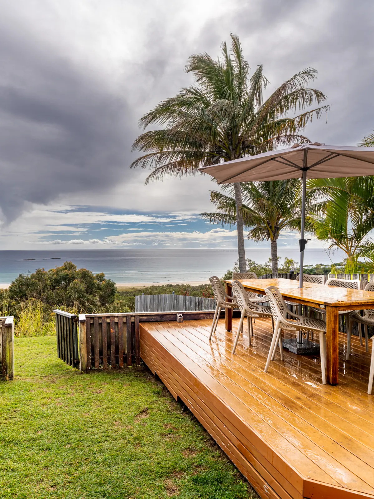 The private deck of a Prestige Headland Ocean 3 bedroom villa, with outdoor dining looking over the headland to the ocean